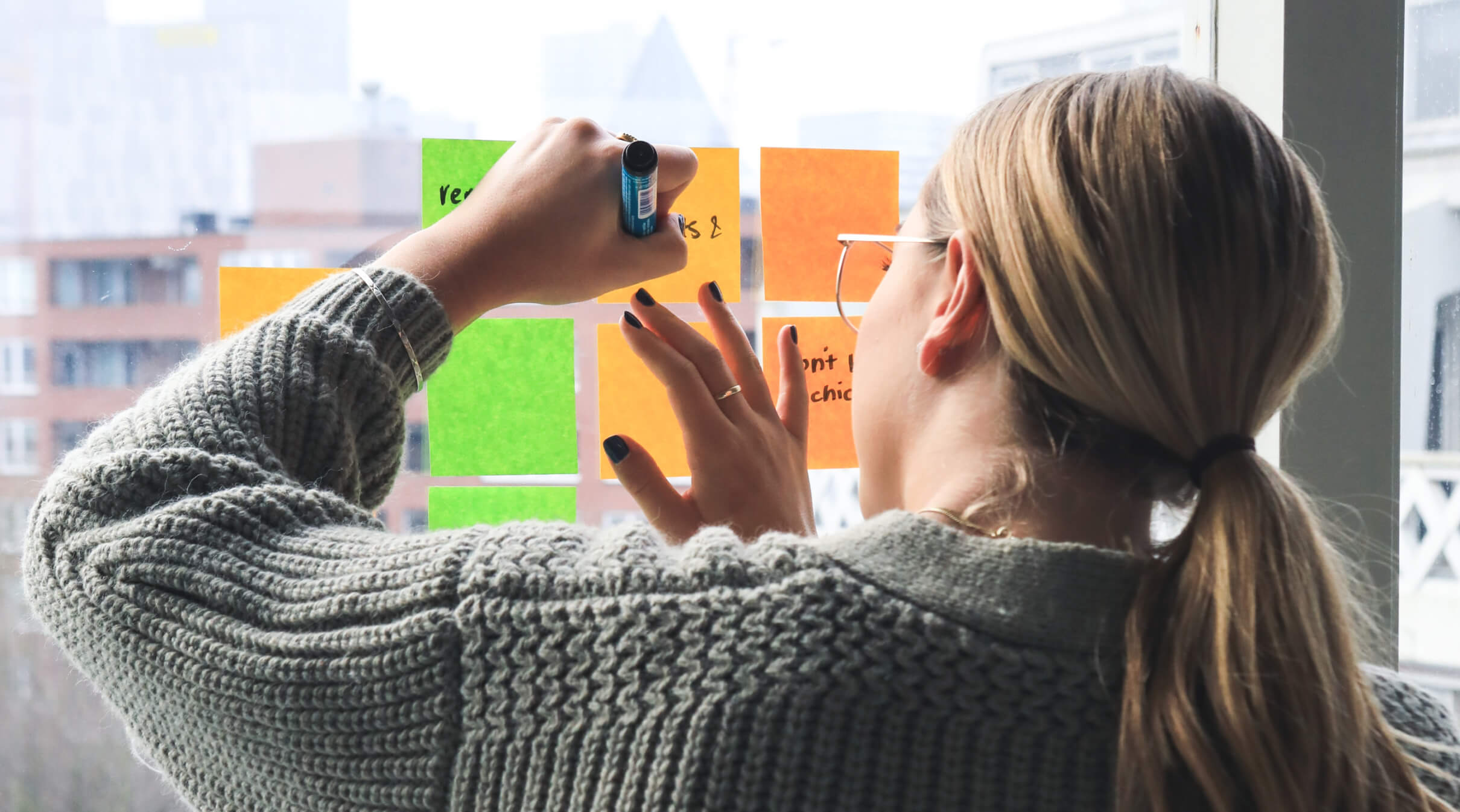 A woman writes ideas on post-it notes